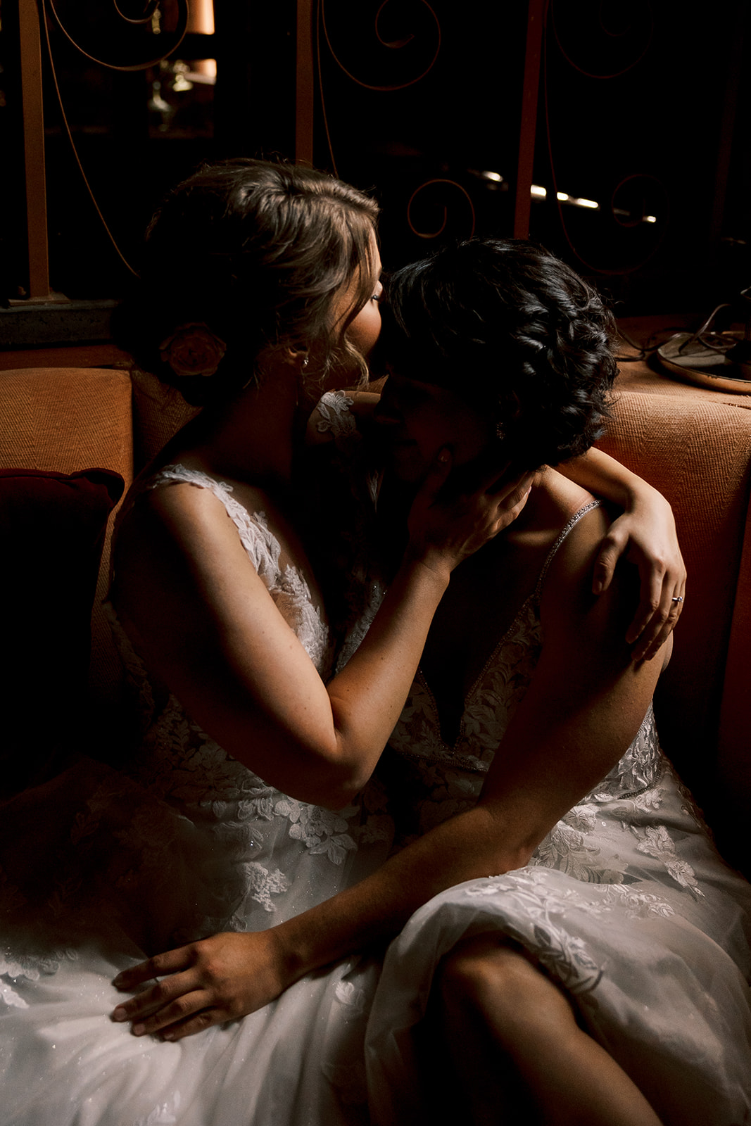 two brides wrapped together sitting on a couch