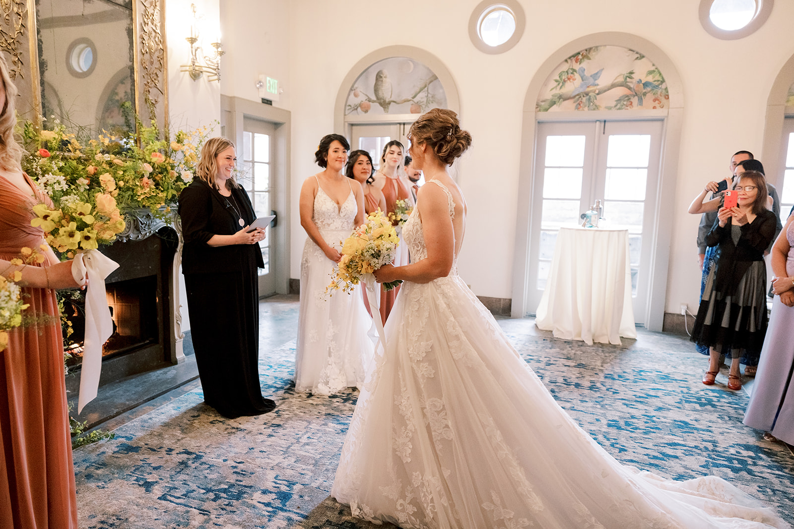 one brides stands at the alter while another bride walks up the aisle during the ceremony