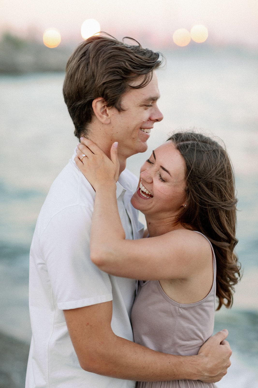 Couple Laughs during engagement shoot on the beach at the Toronto Islands