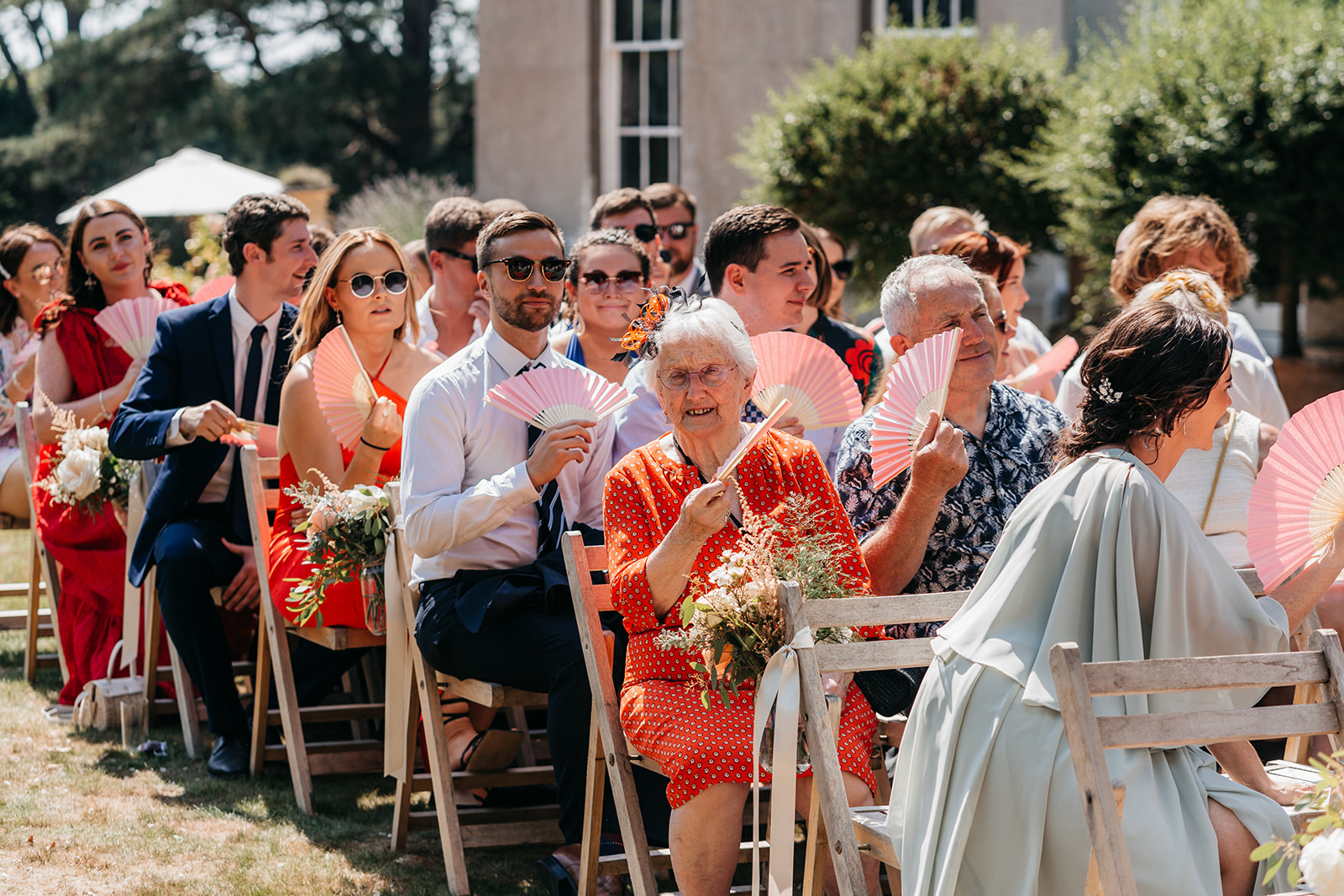 Guests enjoying the wedding ceremony in the sunshine
