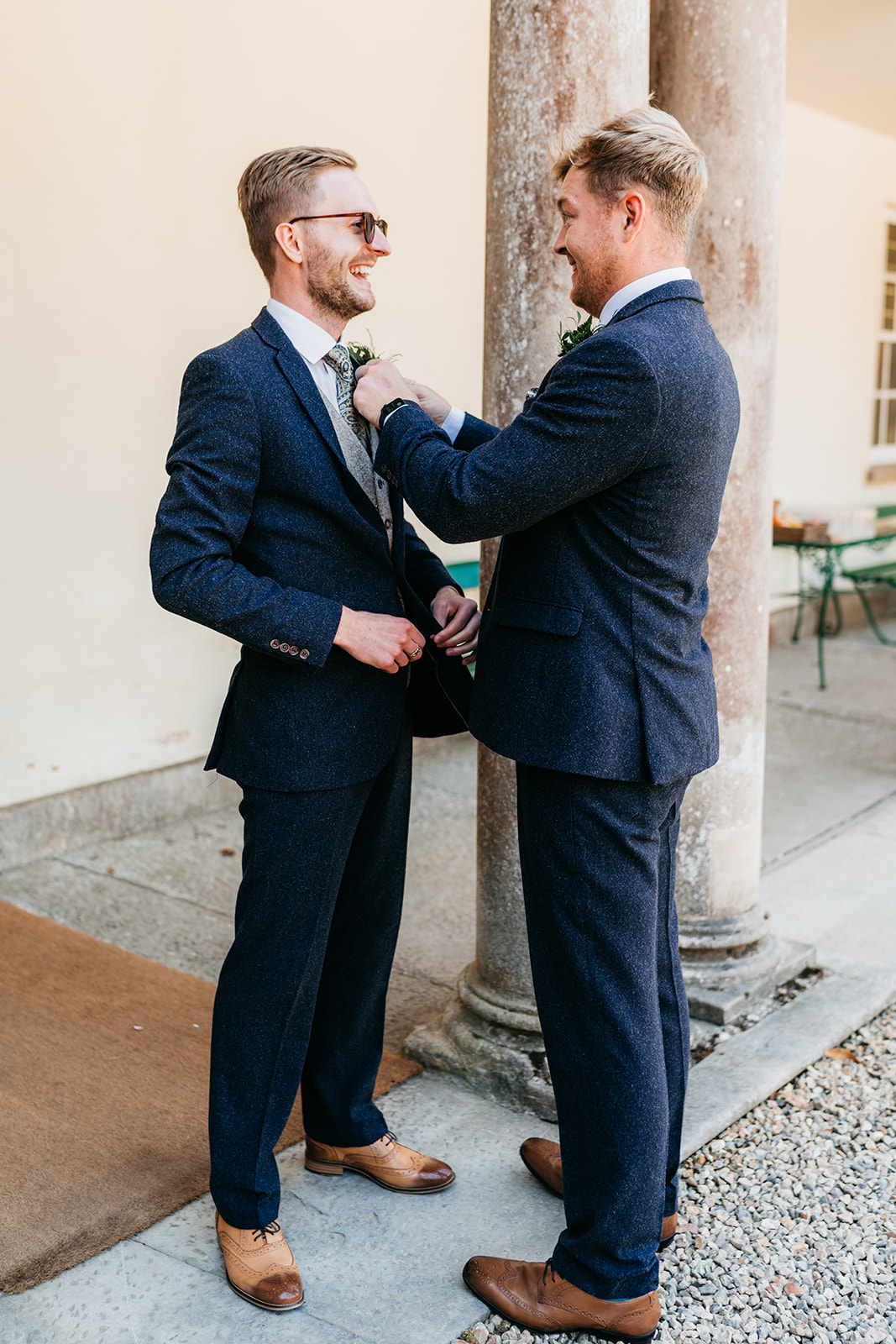 The best man putting on the grooms buttonhole