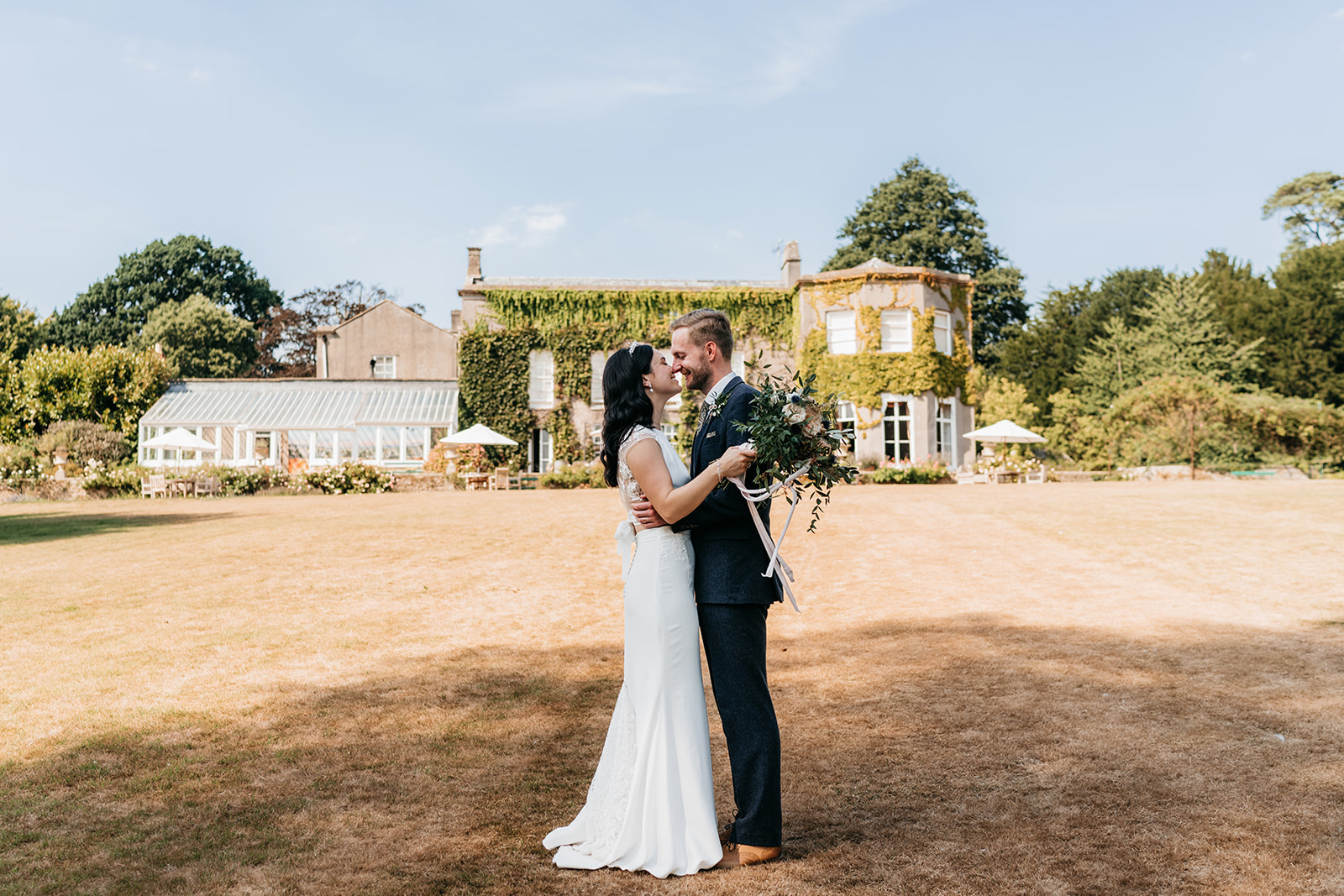 The bride and groom in front of the wedding venue. Pennard house