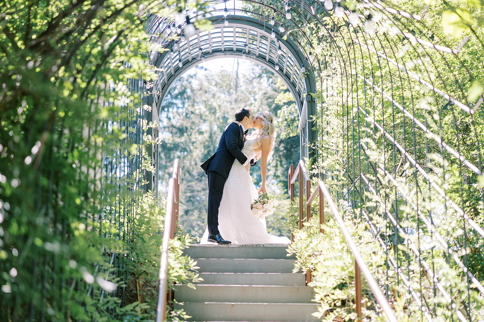 big kiss on outdoor staircase under garden arch