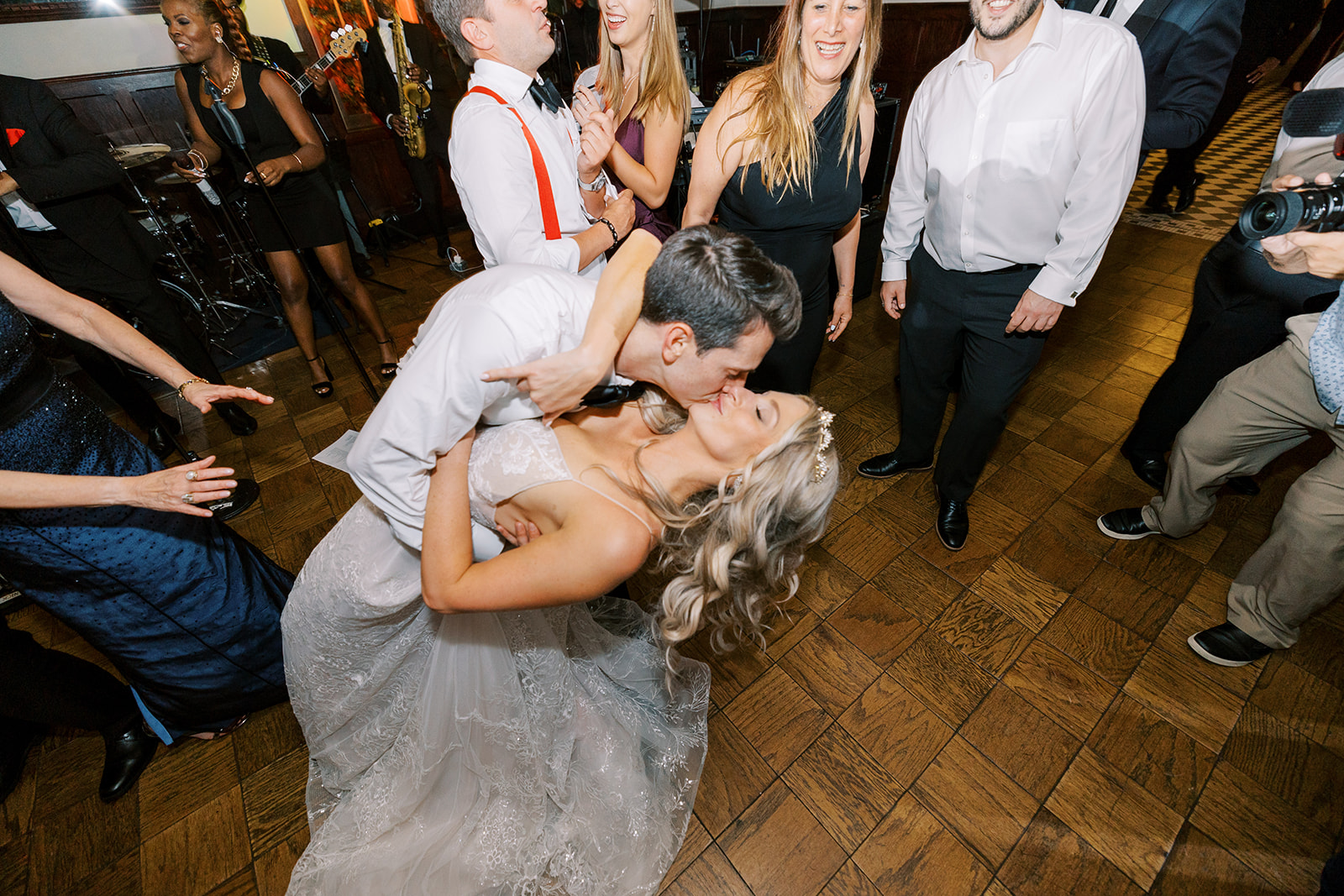 close wide angle dance floor kiss between bride and groom 