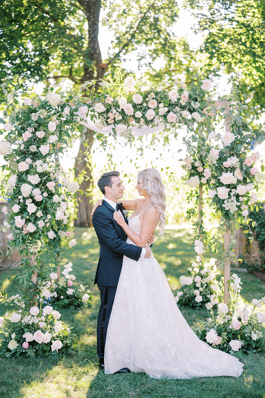 couple hugging in front of ram floral Chuppah Arbor