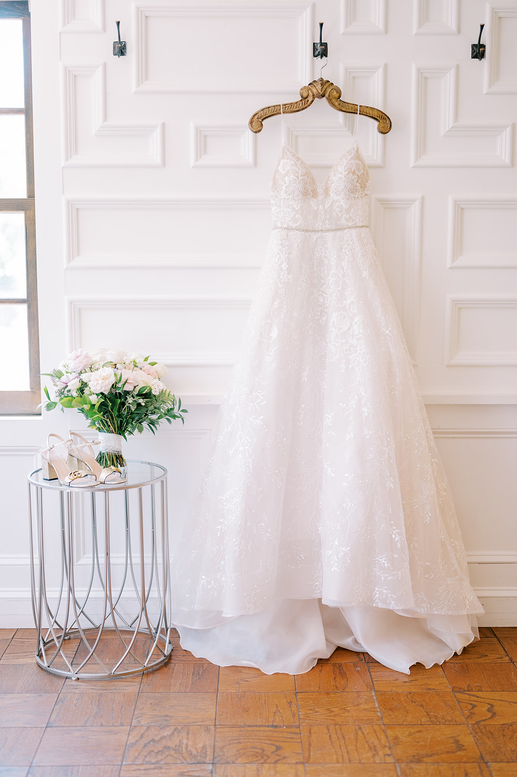 detail photo wedding dress hanging, hanger, bouquet, shoes