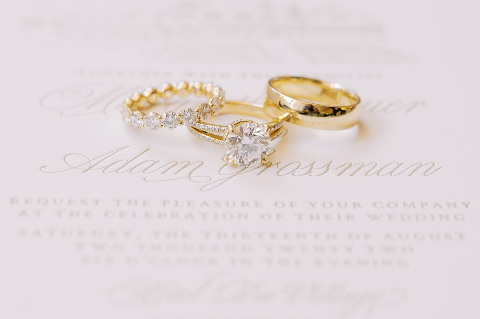 engagement ring with wedding bands on invitation 