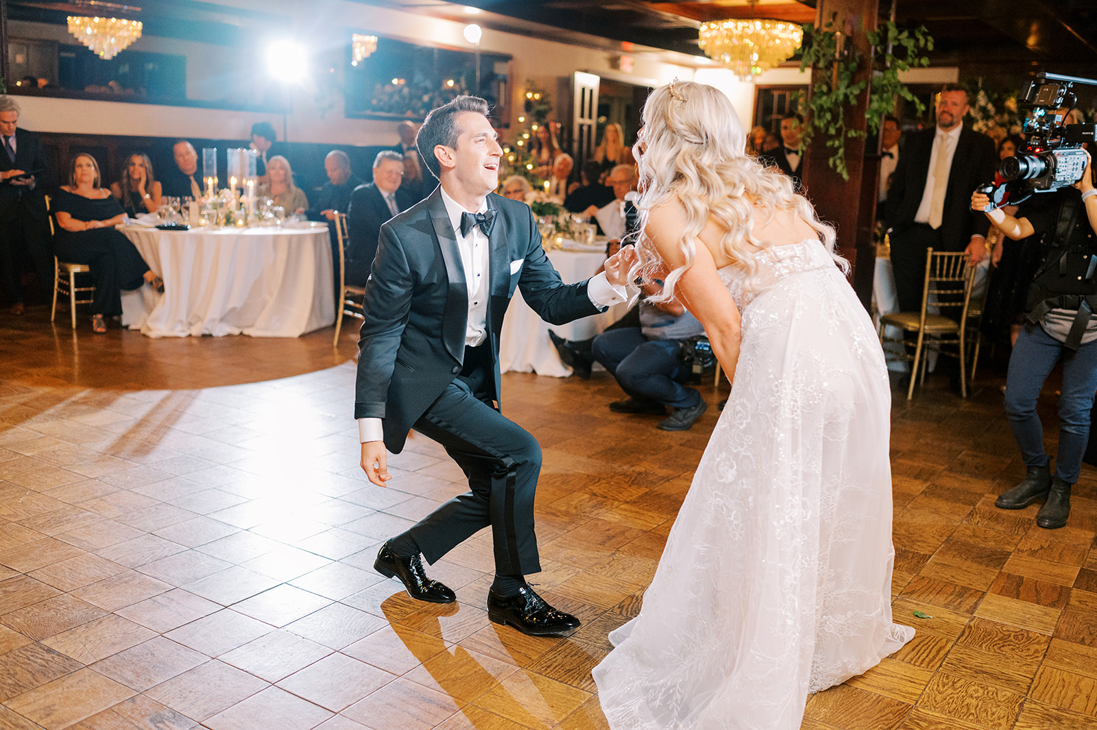 groom showing off his dance moves as bride laughs 