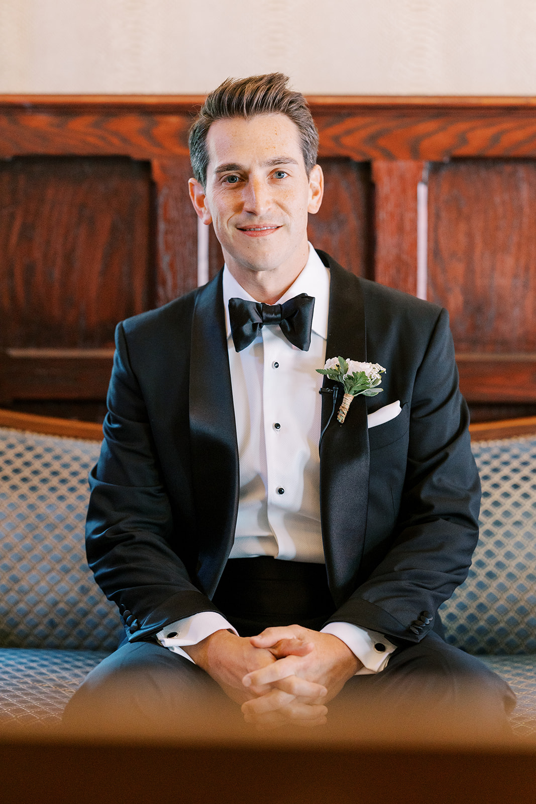 groom in suite pre wedding portrait sitting down black tux