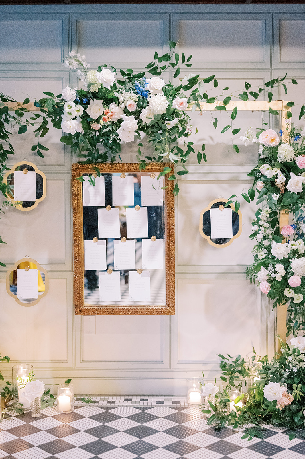 mirrored seating chart with floral installation