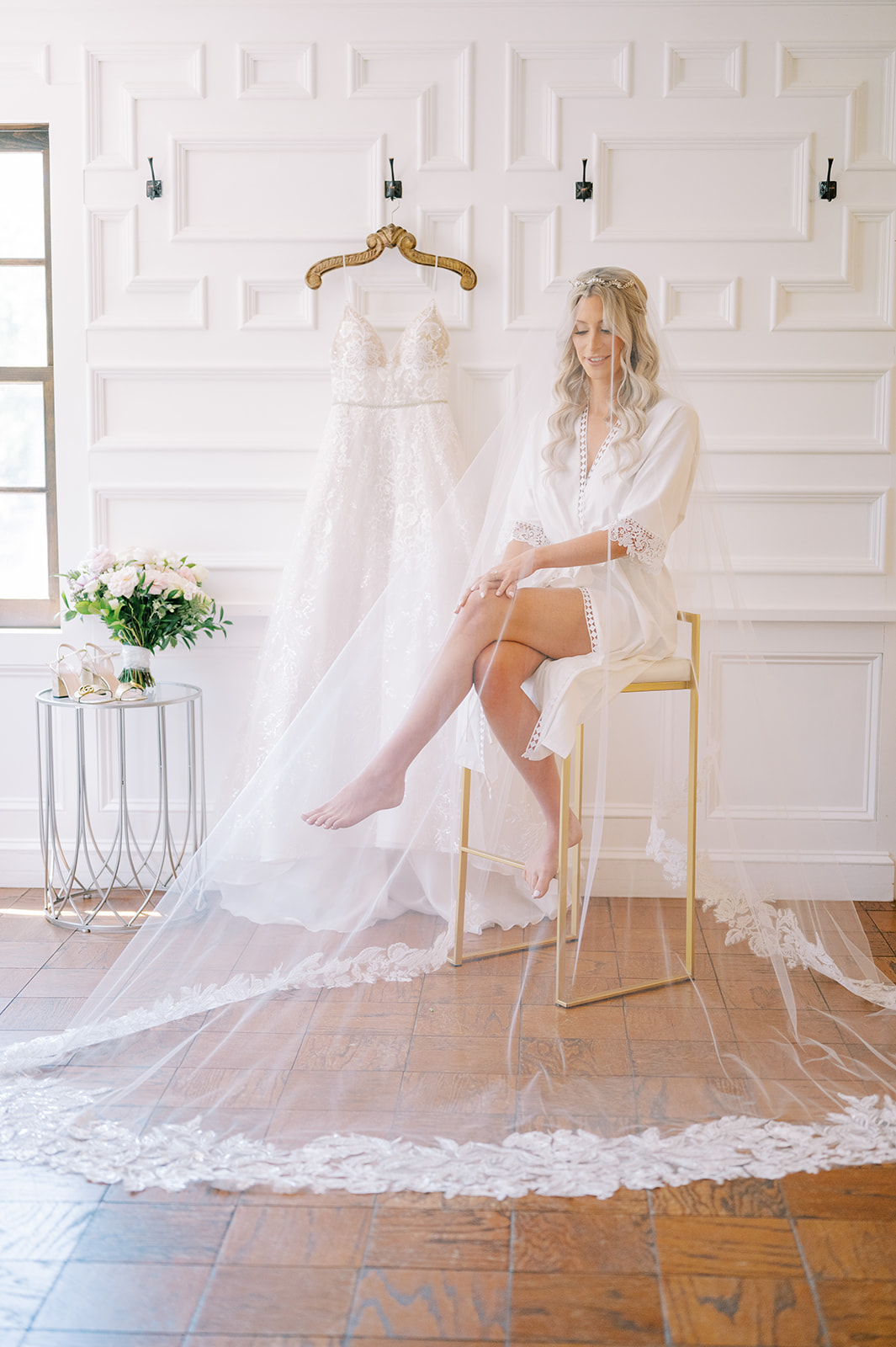 sitting bride prep photo with dress, vail, flowers, shoes in bridal suite in hotel du village 