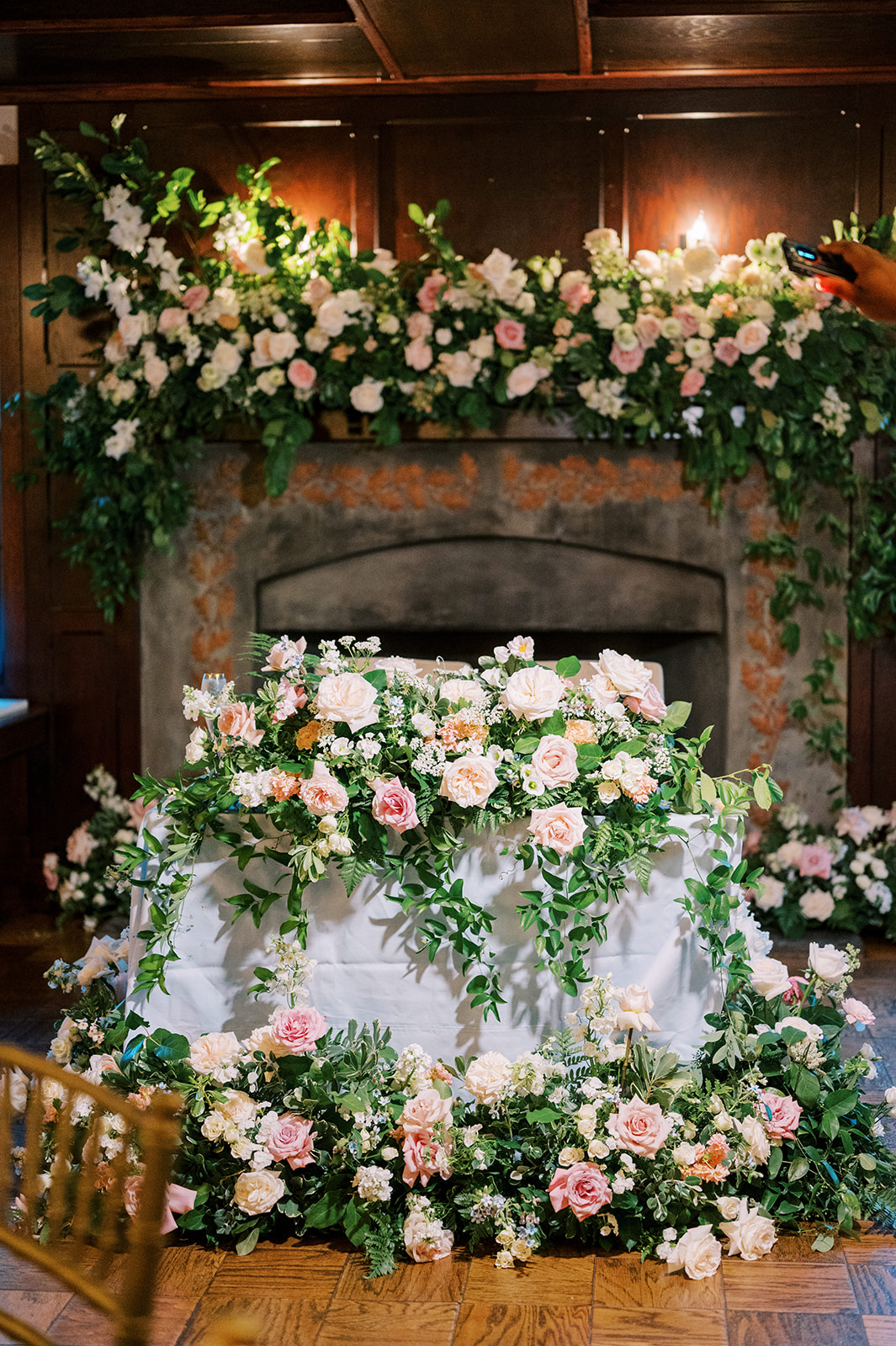 sweetheart table lavishly decorated ram floral in front of a fire place inside colt ballroom hotel du village