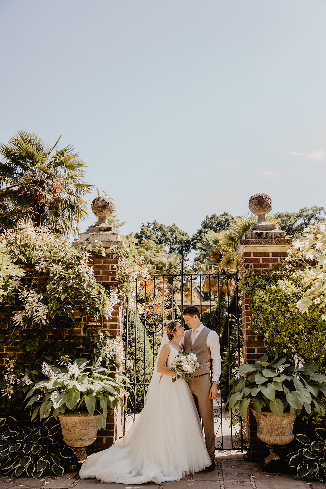 Bride and groom amongst the flowers at a RHS Gardens Wisley Wedding. By Olive Joy Photography