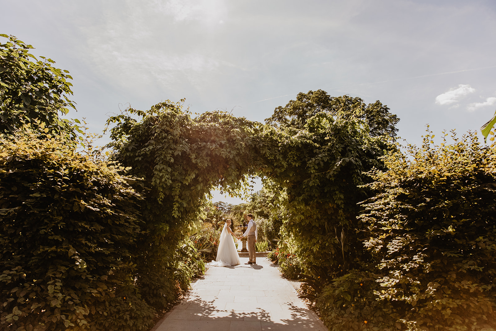 Bride and groom amongst the flowers at a RHS Gardens Wisley Wedding. By Olive Joy Photography