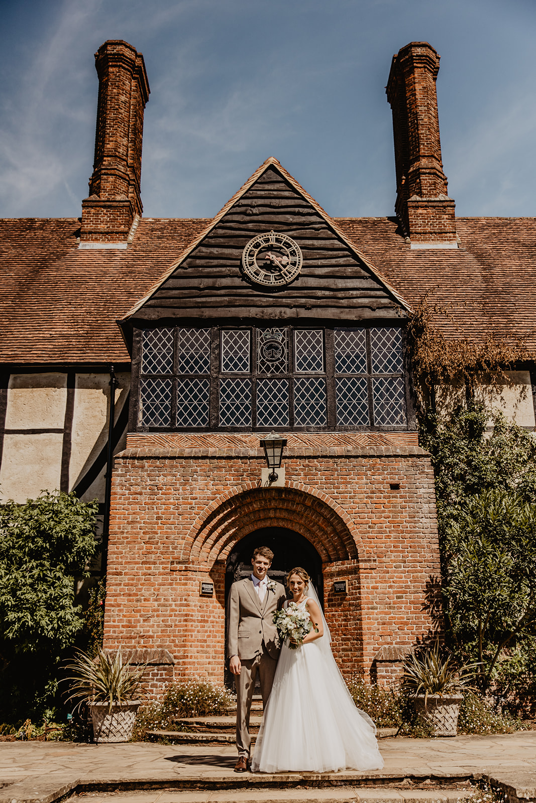 Bride and groom in front of large house at a RHS Gardens Wisley Wedding. By Olive Joy Photography