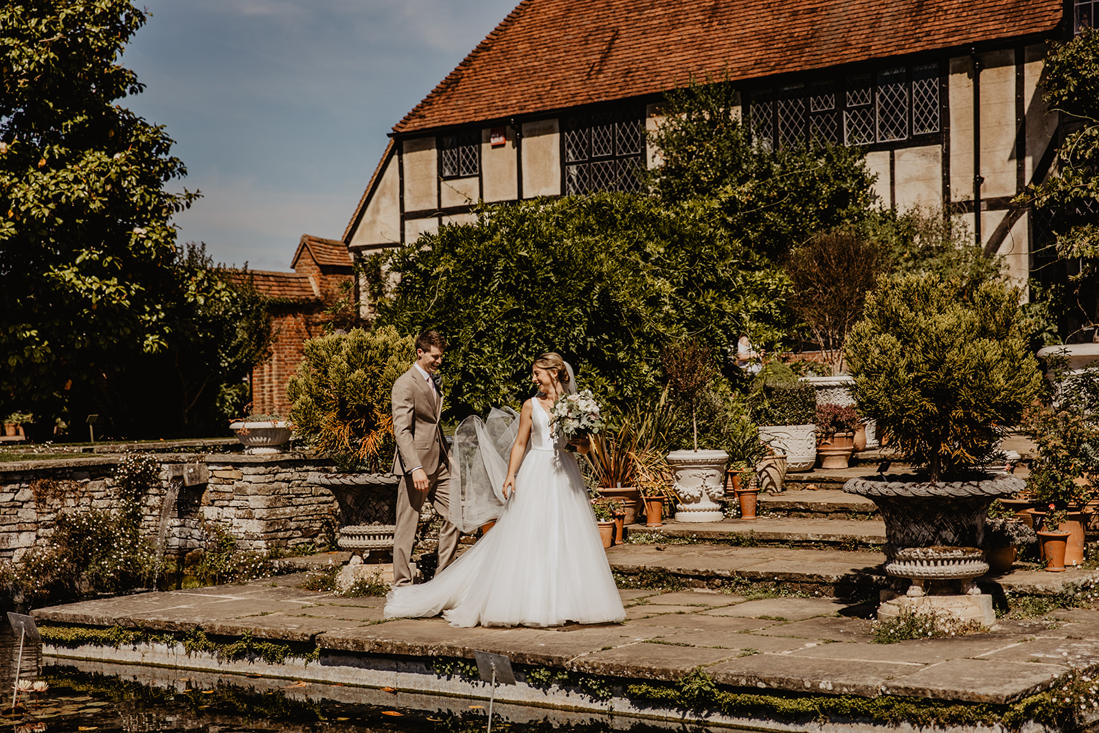 Bride and groom in front of large house at a RHS Gardens Wisley Wedding. By Olive Joy Photography