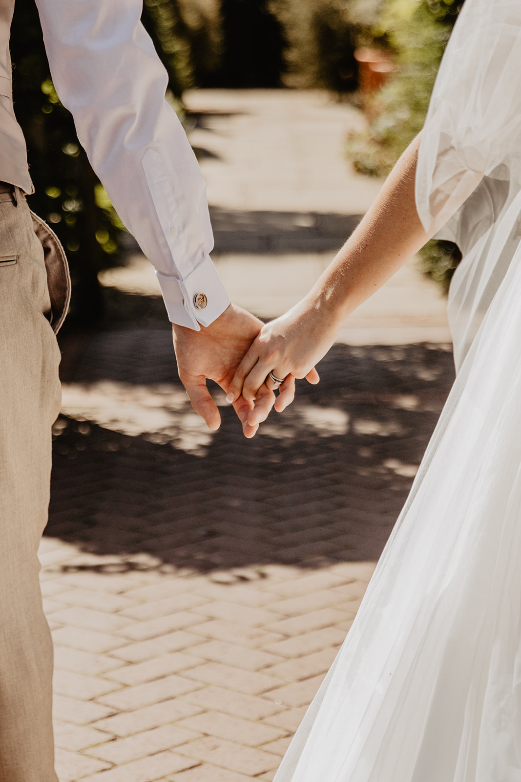 Bride and groom holding hands at a RHS Gardens Wisley Wedding. By Olive Joy Photography
