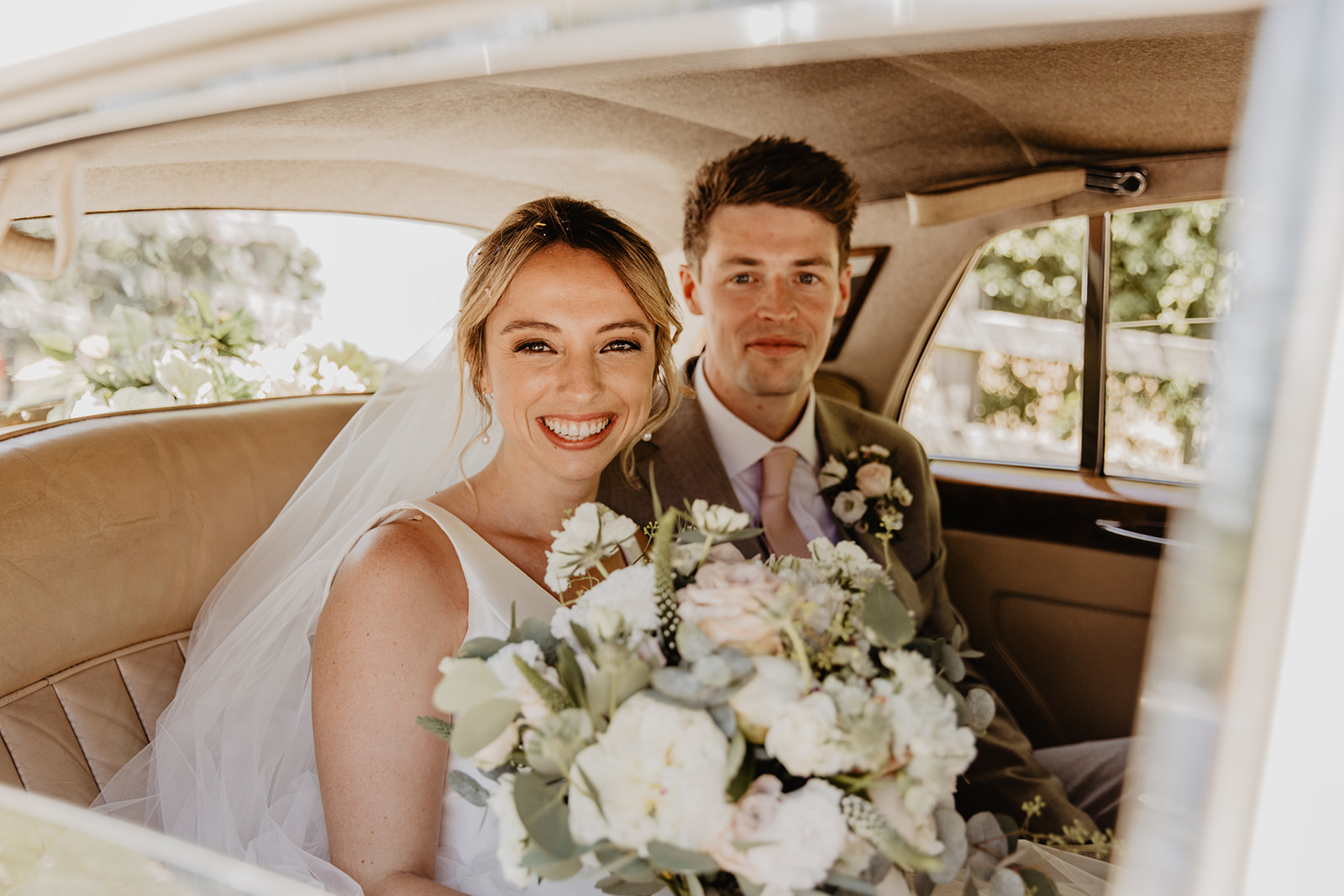 Bride and groom in their wedding car at an RHS Gardens Wisley Wedding. By Olive Joy Photography