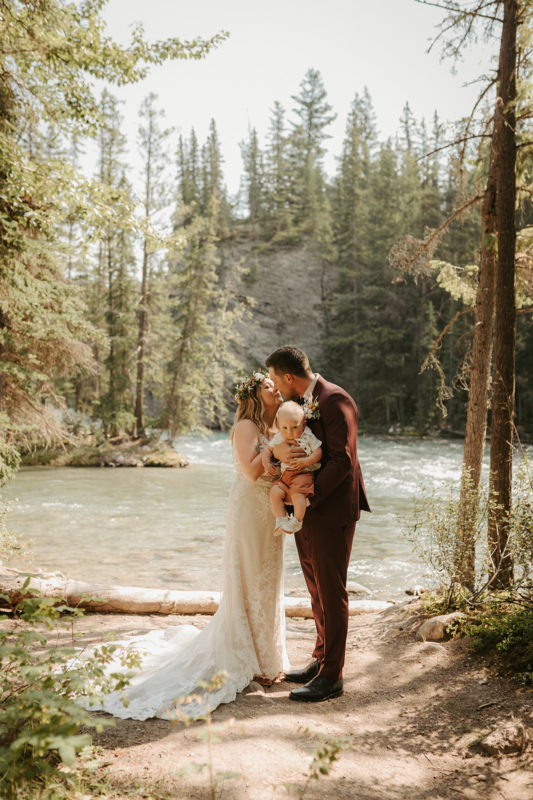 Bride and groom first kiss beside the Athabasca river in Jasper, Alberta. 