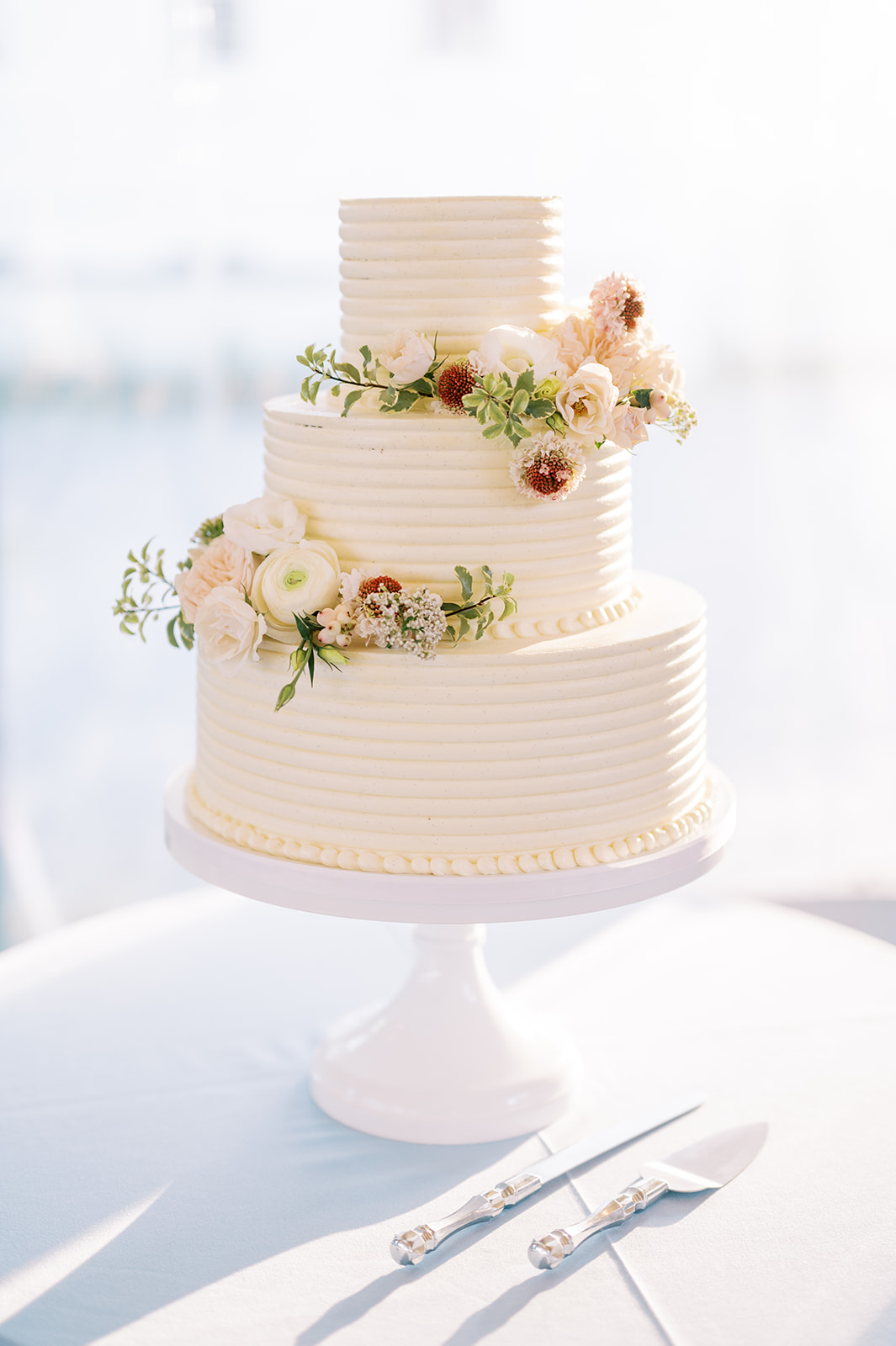 beautiful white cake with romantic florals at Timeless Garden Wedding at Historic Glen Foerd Estate in Philadelphia, PA