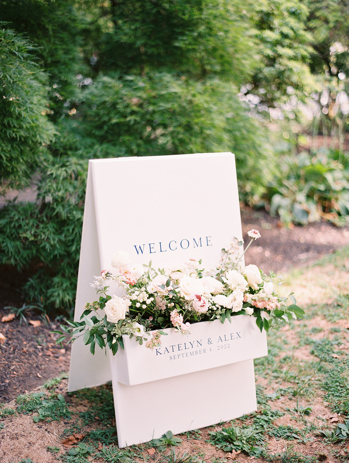 floral adorned welcome sign at Timeless Garden Wedding at Historic Glen Foerd Estate in Philadelphia, PA