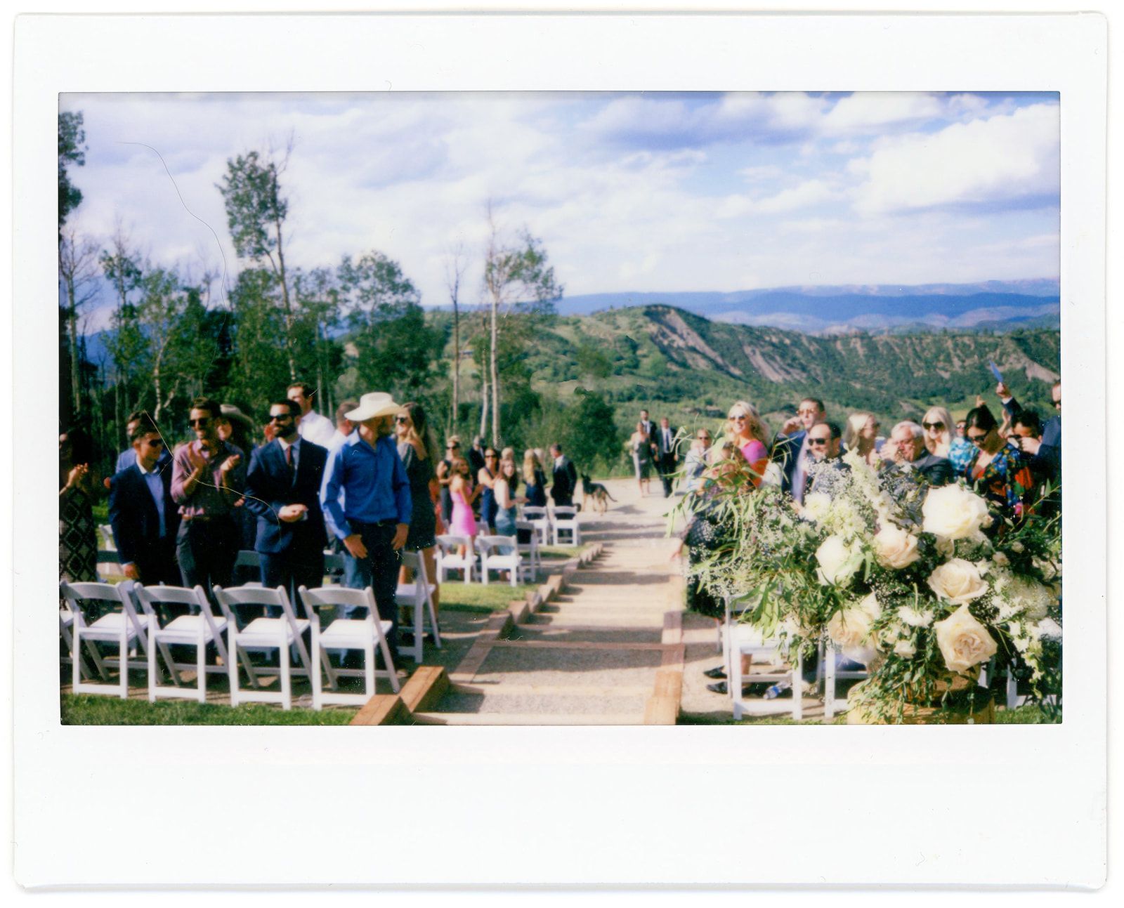 The views of the ceremony location of Limelight wedding terrace. Mountain views and wedding guests. Shot on polaroid.