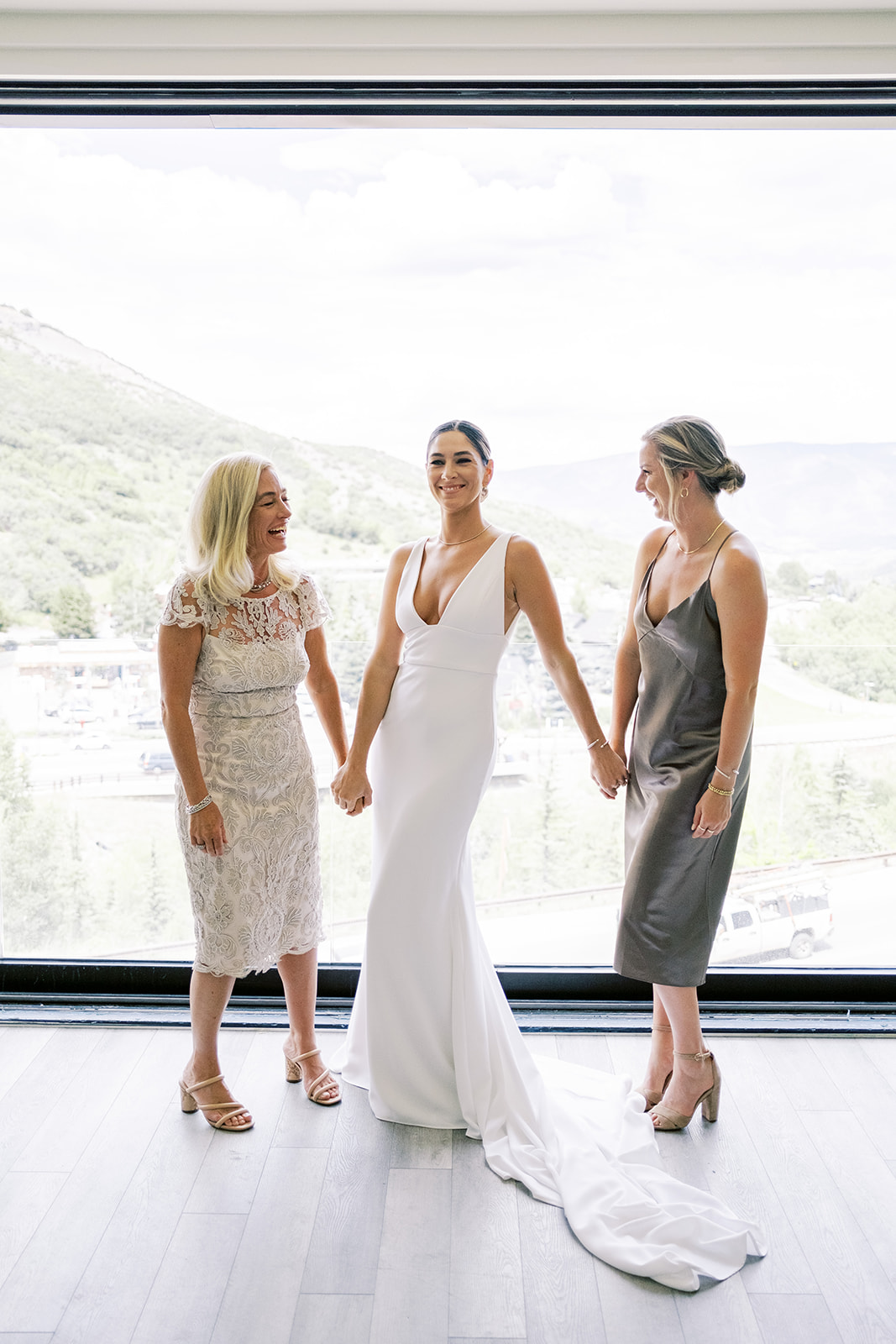 Bride holding hands with two people and laughing