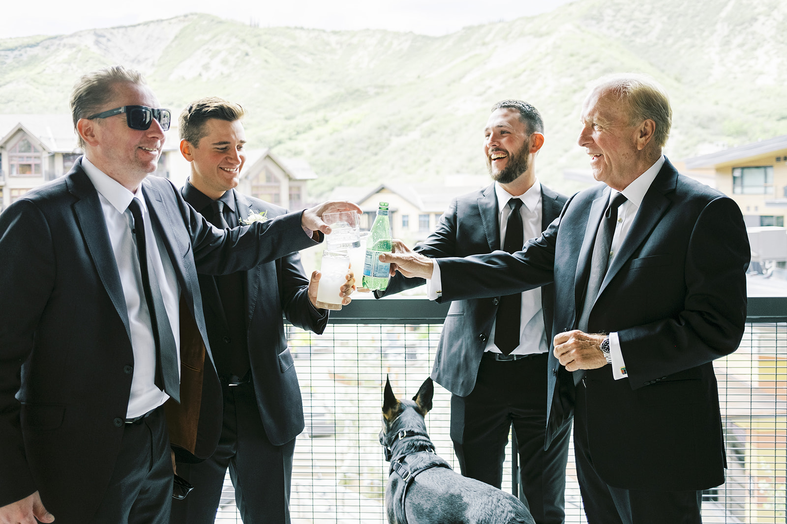 Men in suits giving a cheers with glasses