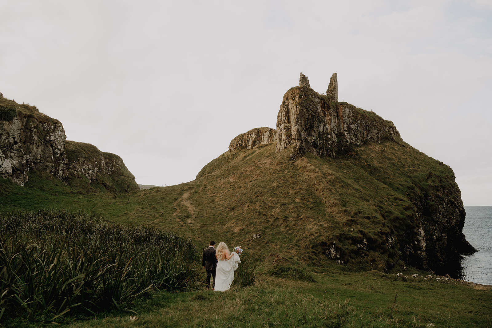 Dunserverick Castle elopement in front of castle ruin at sunset in Northern Ireland