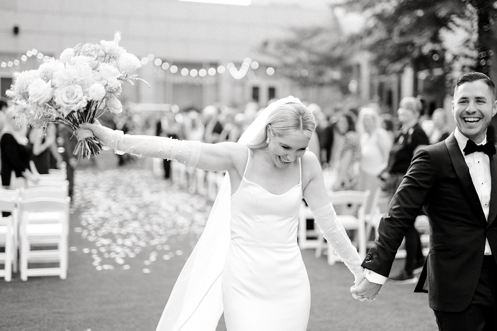 black and white photo of bride and groom celebrating as they exit their chic wedding ceremony at The Logan in Philly, PA
