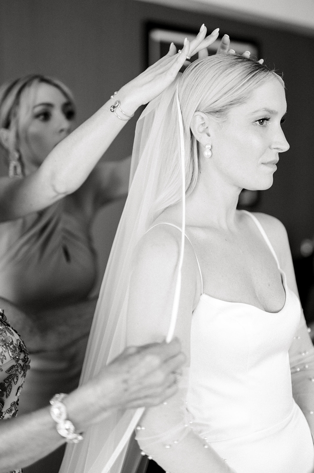black and white photo of bridesmaid adjusting bride's veil at The Logan in Philadelphia, PA 