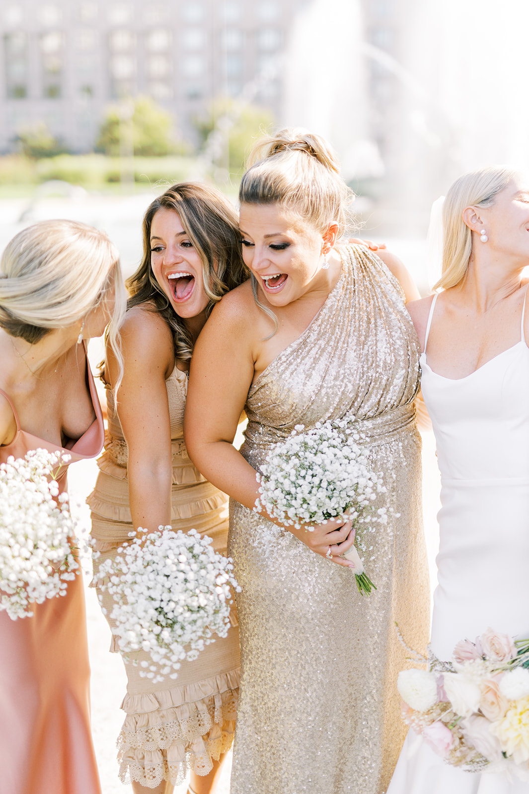 bridesmaids in chic champagne gowns laugh on a sunny wedding day in Philadelphia, PA