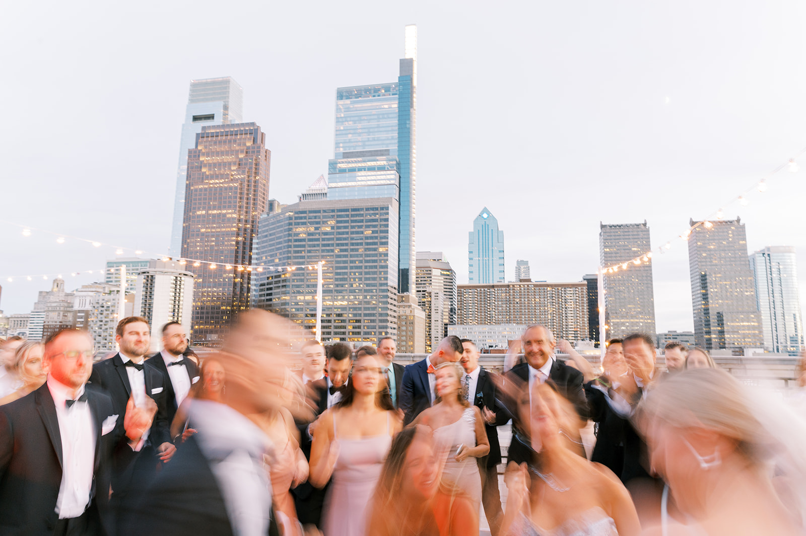 guests dance on rooftop of Free Library of fPhiladelphia with city skyline as a backdrop
