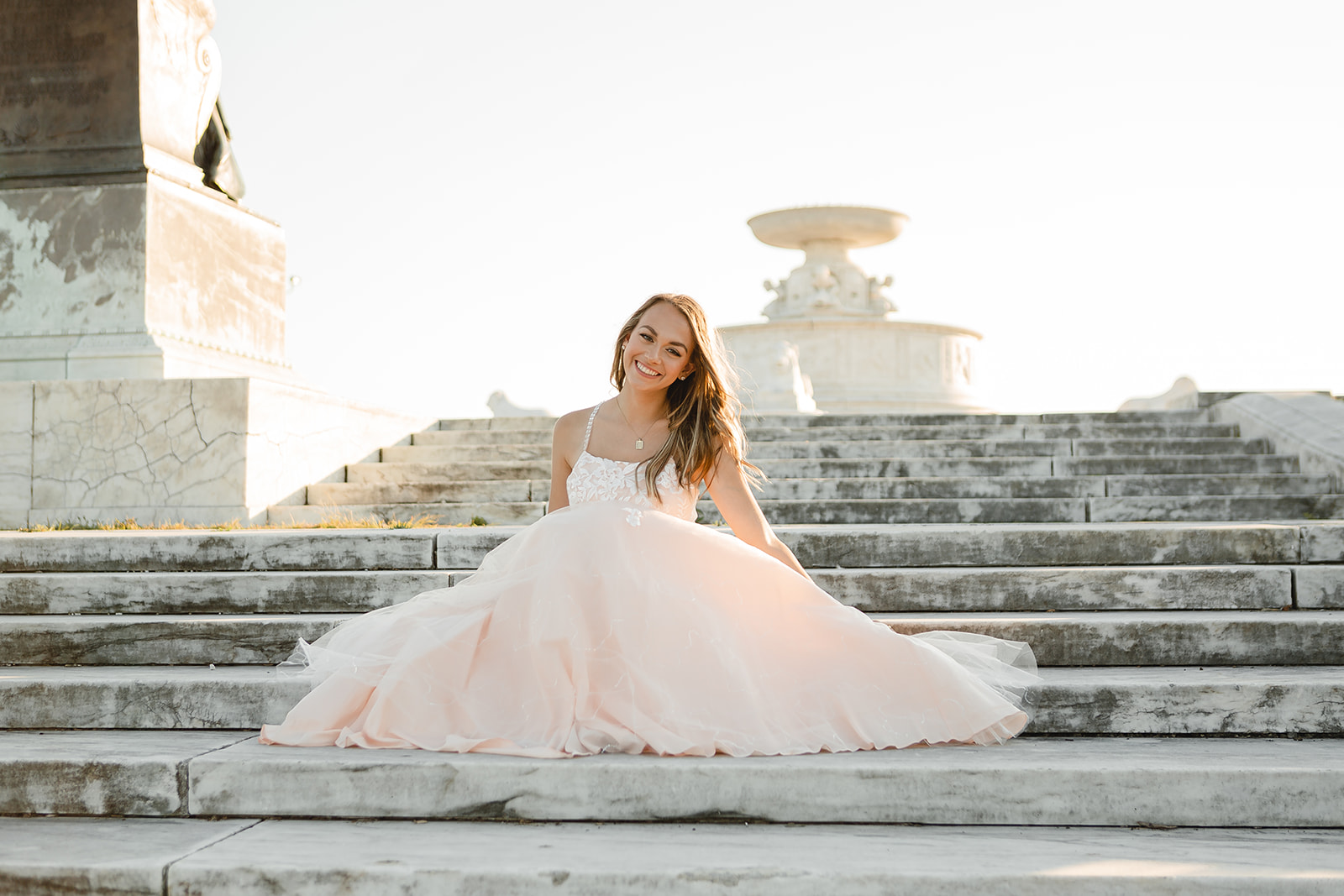 Kenzie on the steps of belle isle at her senior portrait session with studio eleven eleven