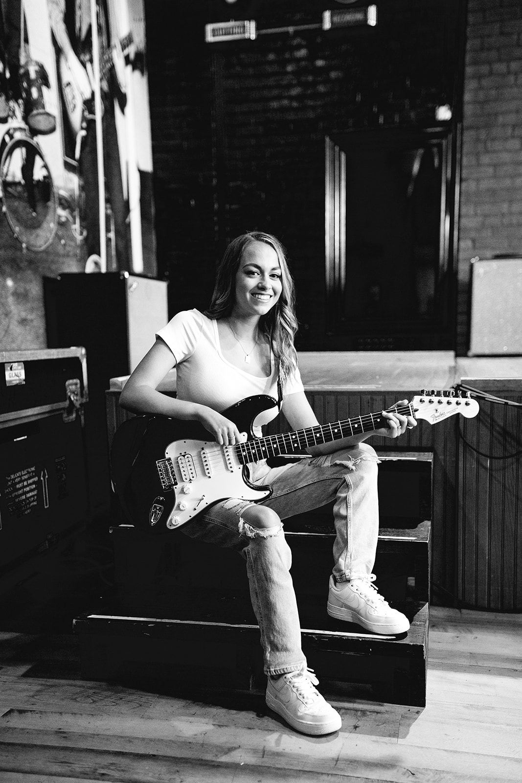 Kenzie playing guitar at a downtown Detroit record store at her senior portrait session