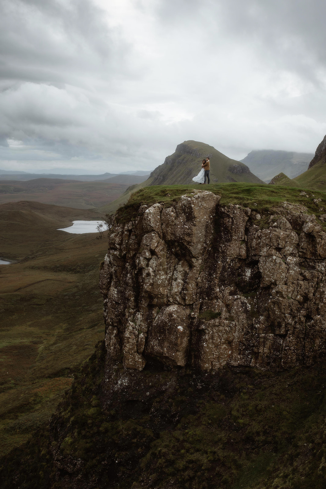 Alex and Elliot stand at the edge of a cliff at the Isle of Skye, Scotland during their adventure session