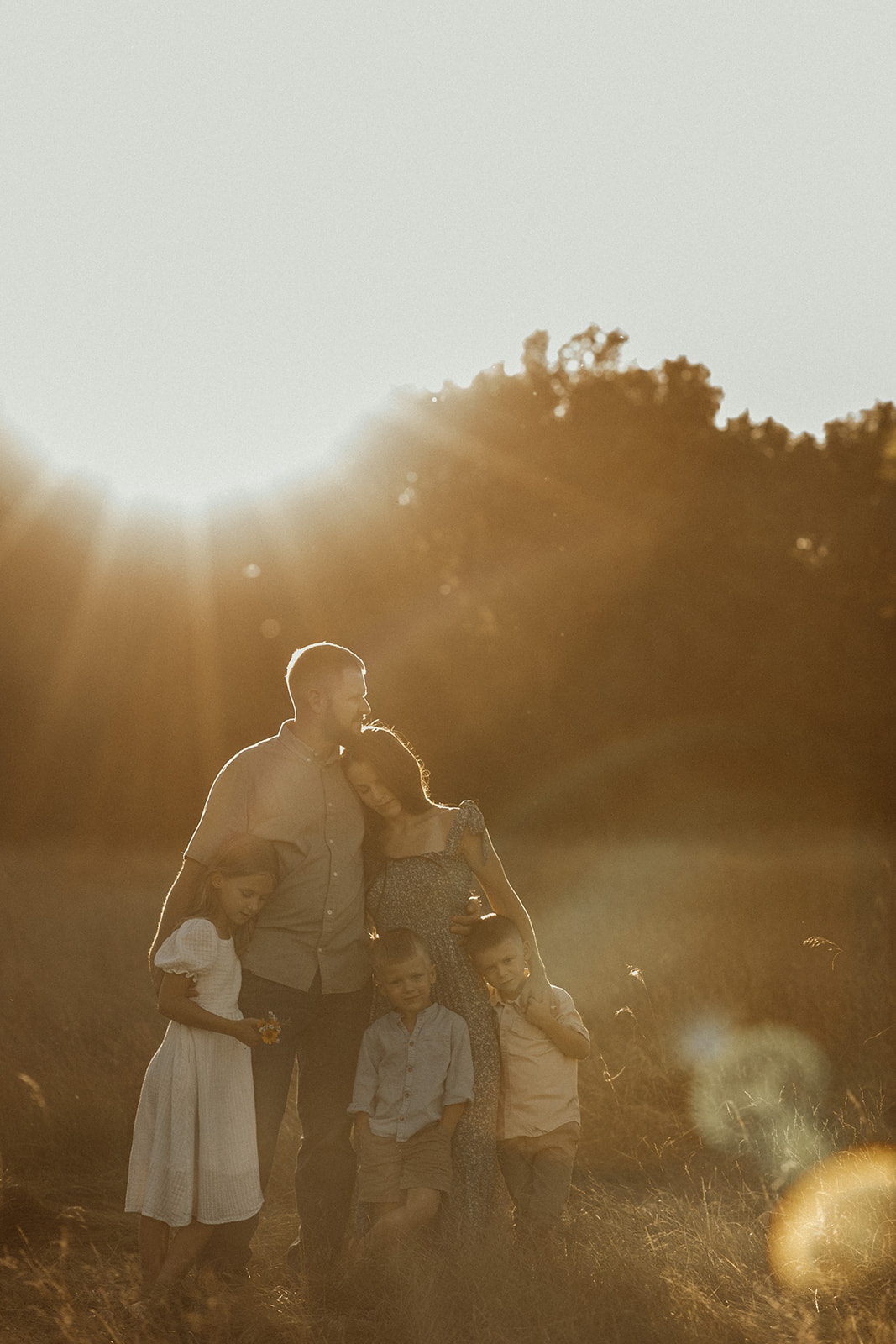 Family portrait in a field at sunset