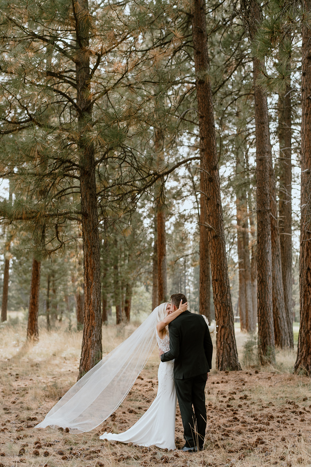 Bride and groom first look and portraits in the woods with tall pine trees in Bend Oregon
