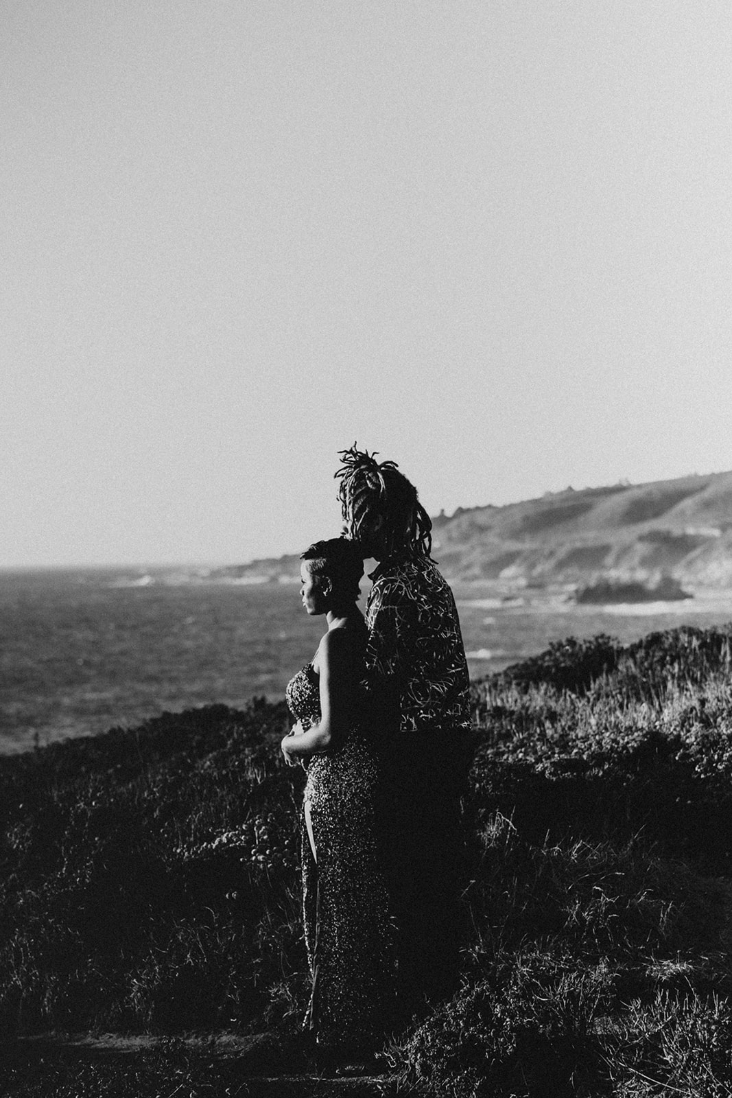 Black and white image of posed couple on california coastline