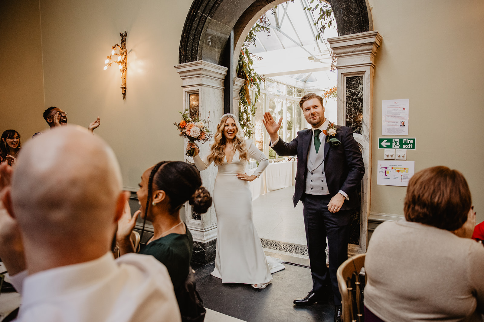 Bride and Groom entering reception at Hampton Court House on their Wedding Day. By Olive Joy Photography