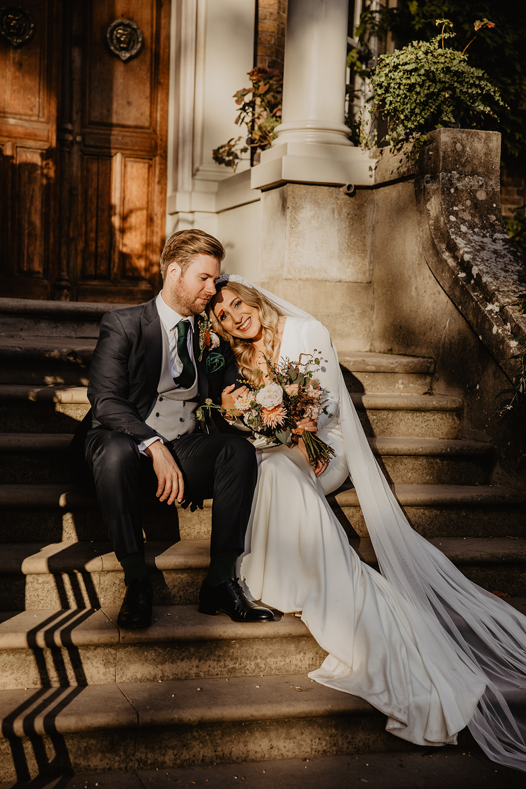 Bride and Groom in front of Hampton Court House on their Wedding Day. By Olive Joy Photography