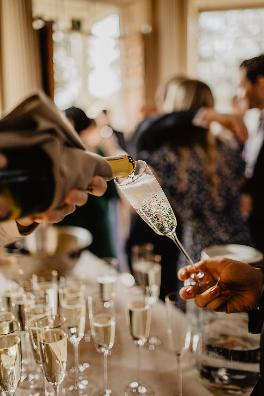 Champagne being poured at a Hampton Court House Wedding. By Olive Joy Photography