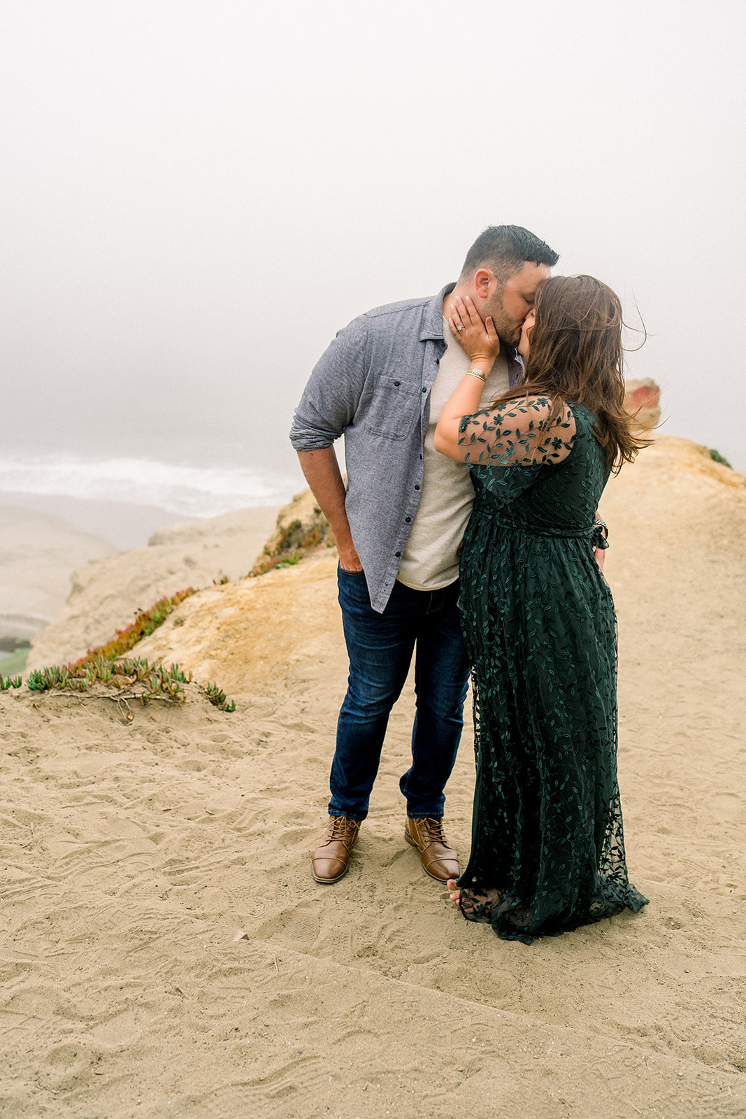 A couple celebrates their engagement in the fog at Lands End San Francisco CA