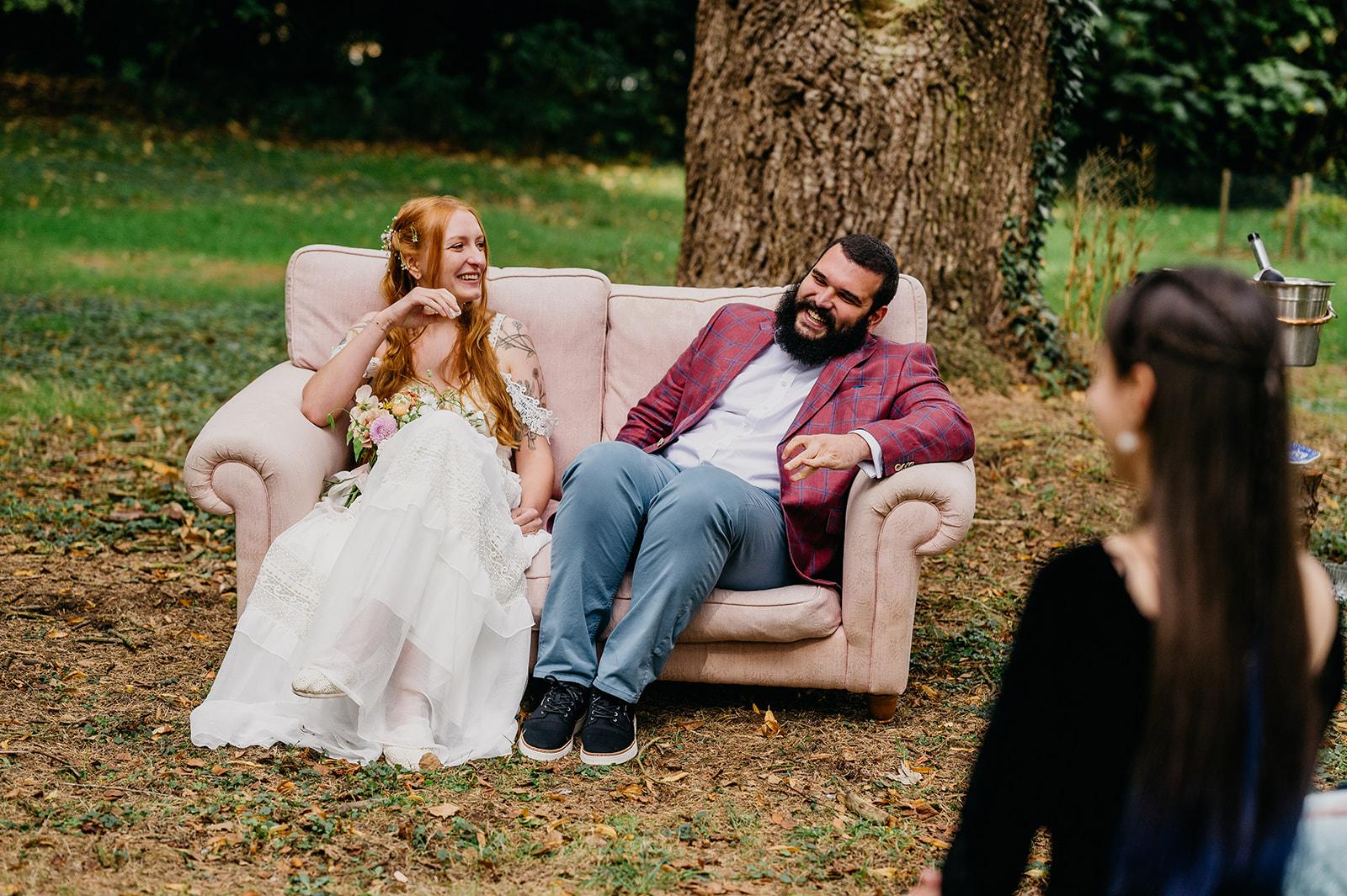 couple relax on a sofa during their woodland wedding ceremony at broadfield court