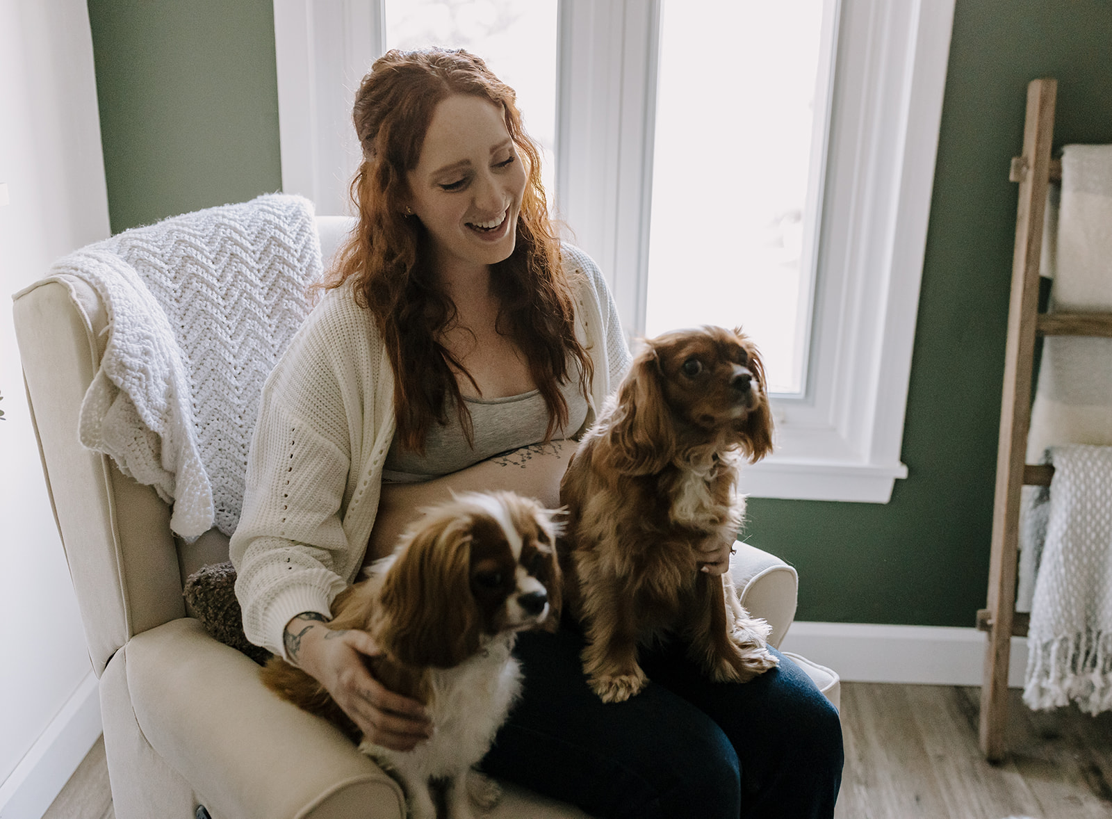 pregnant woman sitting with two dogs in lap
