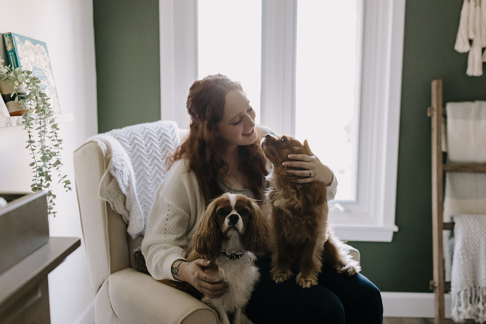 pregnant woman sitting with two dogs in lap