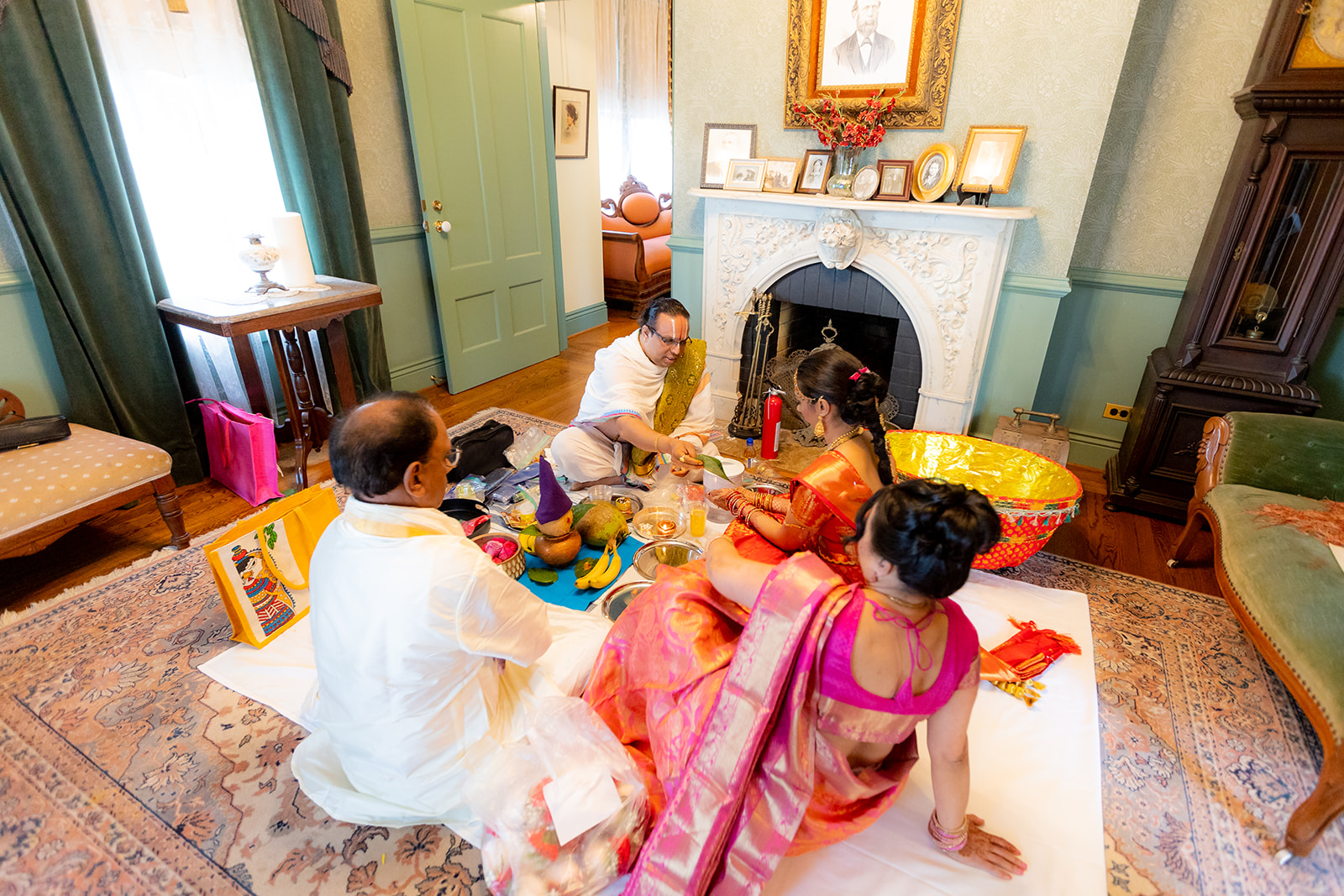 Bride and family sit with priest at indian wedding ceremony at Renstorff house, a bay area wedding venue
