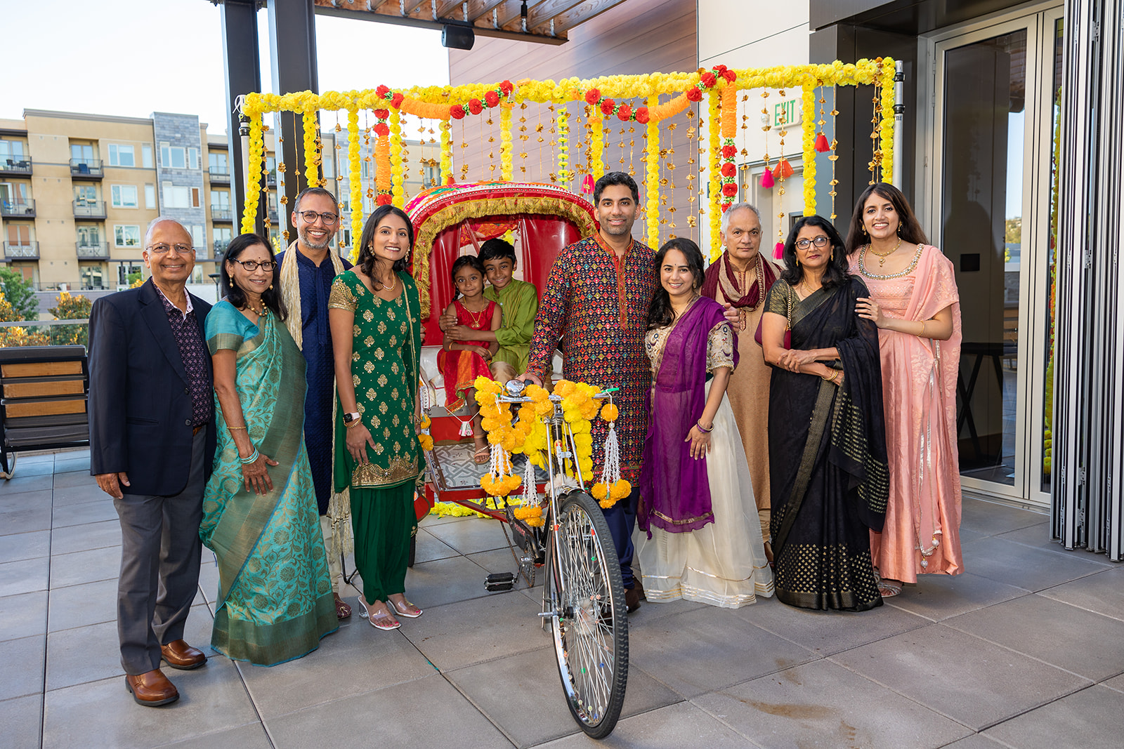 Family photo with Indian bike taxi set up at Hyatt Centric Hotel for an Indian Wedding Sangreet ceremony.
