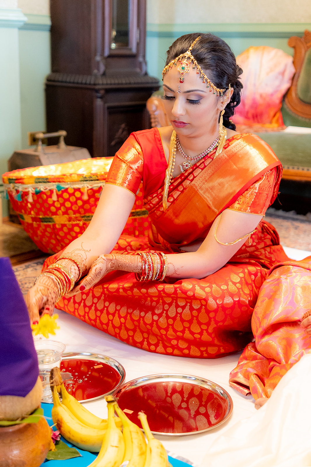 Indian bride accepts wedding spices and fruits blessings before wedding ceremony.