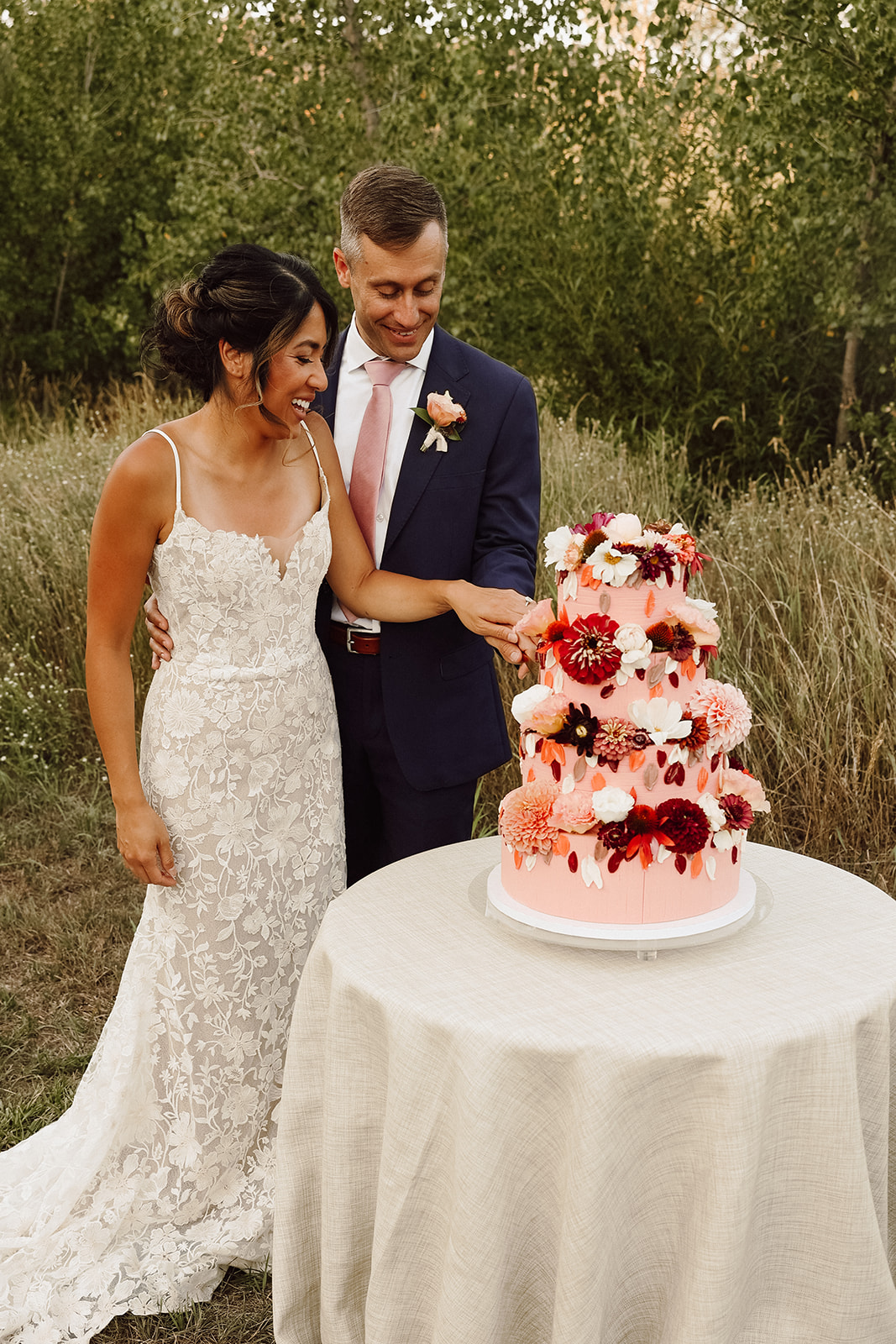 Bride and groom cutting their pink cake 